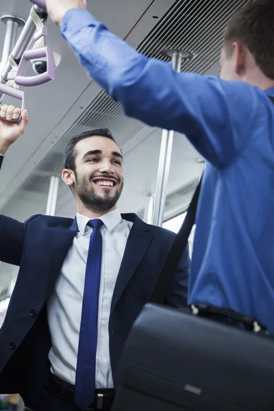 Businessmen talking on the subway — Stock Photo, Image