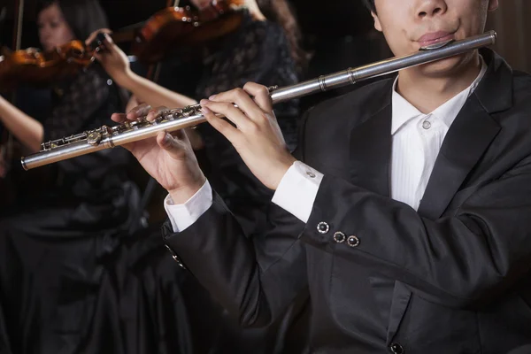 Flautist holding and playing the flute — Stock Photo, Image