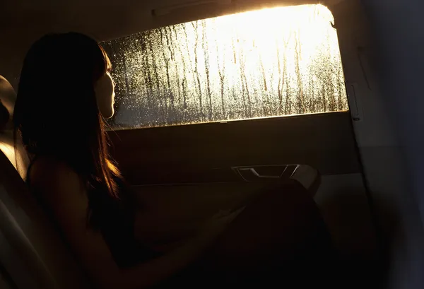 Kobieta patrząc przez okno samochodu — Zdjęcie stockowe