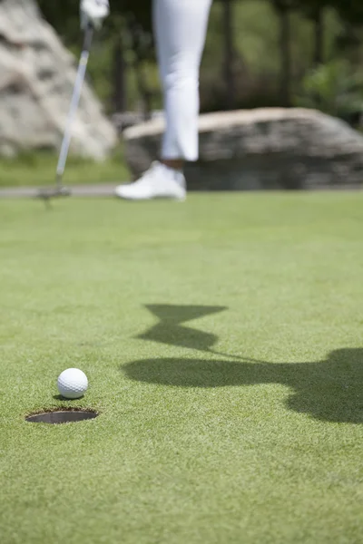 Vrouw raken van de bal op de golfbaan — Stockfoto