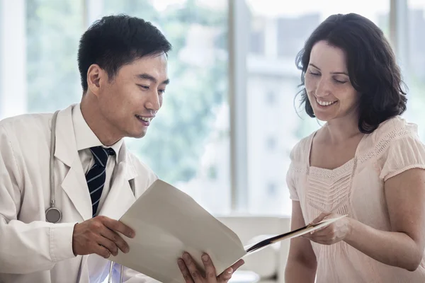 Médico y paciente discutiendo historia clínica — Foto de Stock