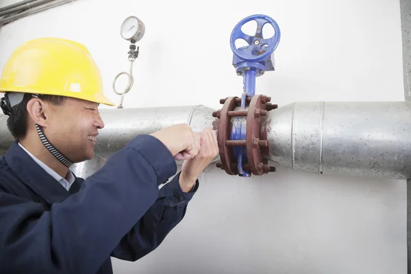 Werknemer controleren de olie pijplijn apparatuur in een gasfabriek — Stockfoto
