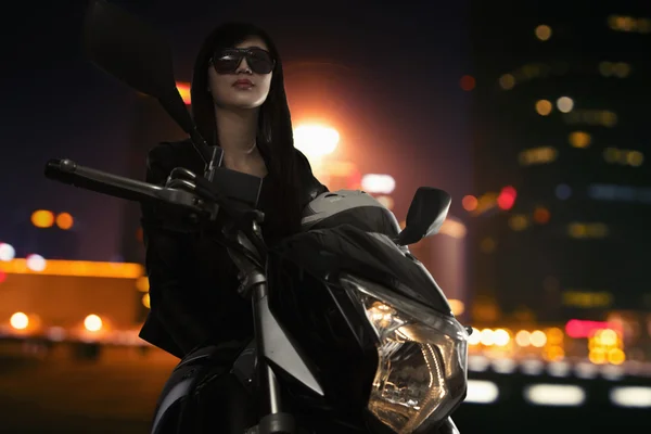 Femme assise sur une moto la nuit — Photo