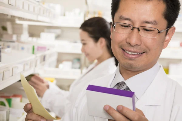 Farmacêutico examinando medicamentos prescritos — Fotografia de Stock