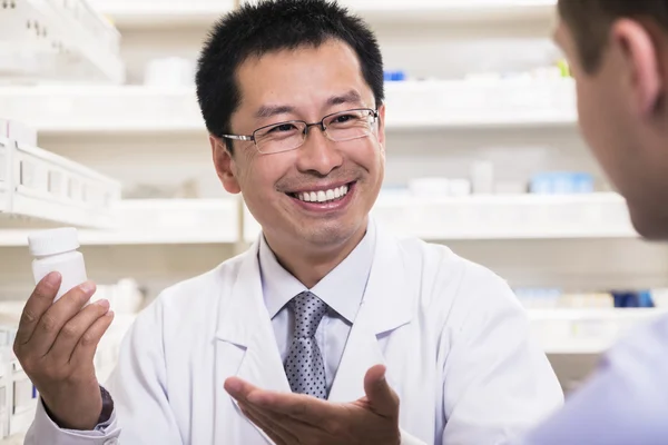 Pharmacist showing prescription medication to a customer — Stock Photo, Image