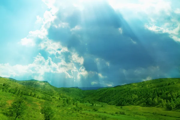 Paisaje verde con sol brillando a través de nubes —  Fotos de Stock