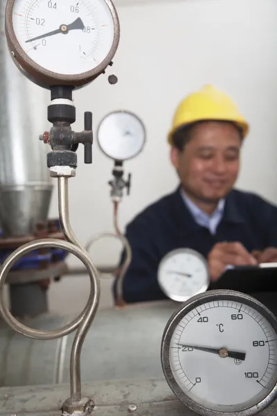 Gas gauges with worker in the background — Stock Photo, Image