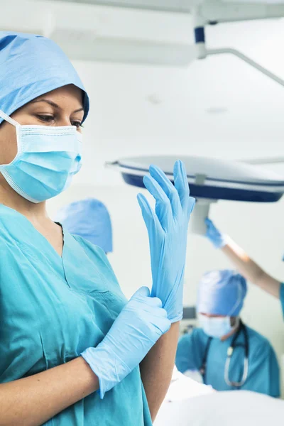 Surgeon putting on gloves in the operating room — Stock Photo, Image