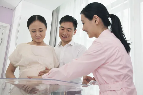 Nurse touching pregnant woman's belly — Stock Photo, Image