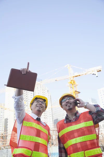 Architetti che guardano e puntano al cantiere — Foto Stock