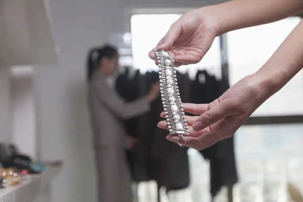 Mujer sosteniendo la pieza de joyería en la tienda —  Fotos de Stock