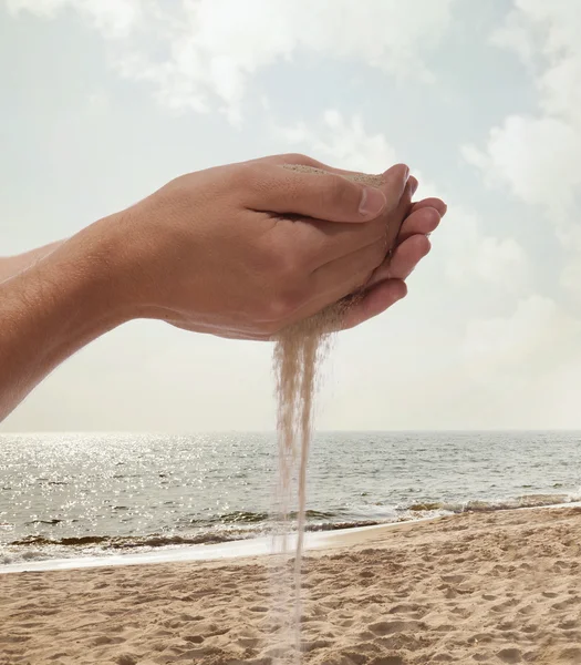 Händerna håller och spilla sand — Stockfoto