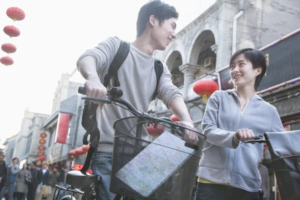 Мужчина и женщина с велосипедами и картой — стоковое фото