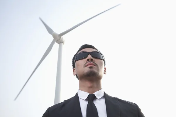 Affärsman står av ett vindkraftverk — Stockfoto
