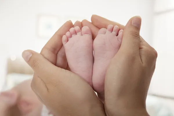 Mutter hält die Füße ihres Babys — Stockfoto