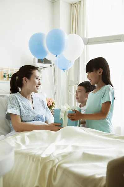 Girl and boy visiting their mother in the hospital — Stock Photo, Image