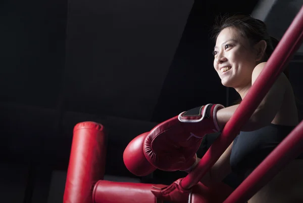 Mulher boxer descansando seus cotovelos no lado do anel — Fotografia de Stock