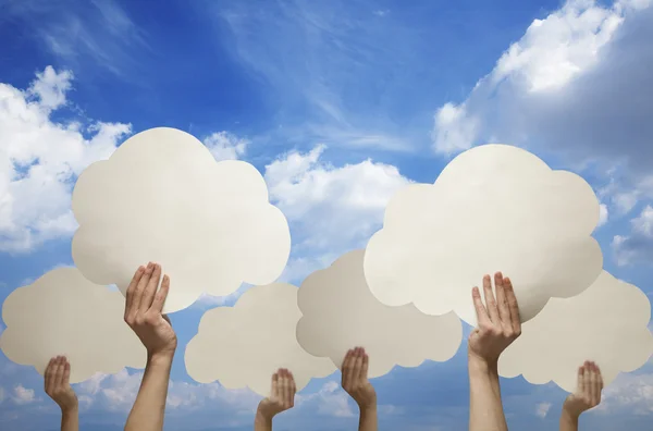 Hands holding cut out paper clouds