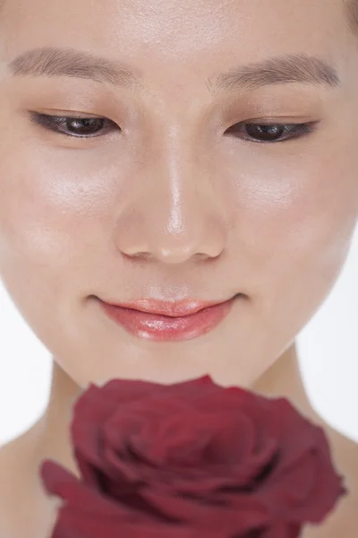 Woman looking down at a red rose — Stock Photo, Image