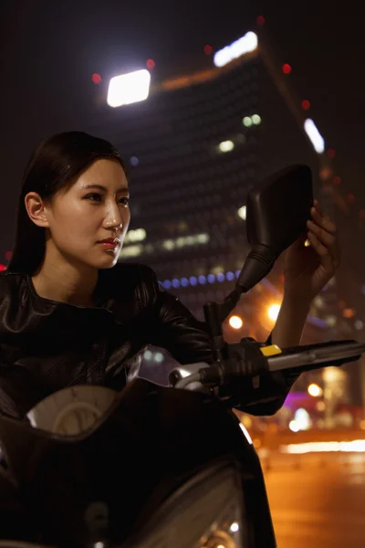 Frau überprüft sich im Seitenspiegel eines Motorrads — Stockfoto