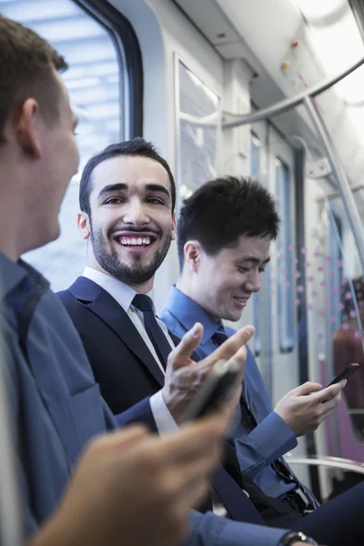 Businessmen talking on the subway — Stock Photo, Image