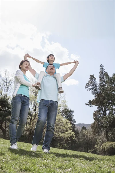 Familjen i parken med son på pappas axlar — Stockfoto