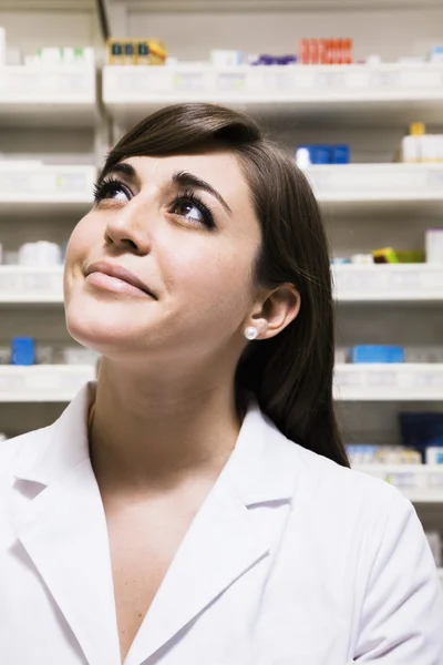 Pharmacist looking up in a pharmacy — Stock Photo, Image