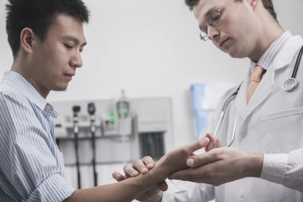 Arzt überprüft Puls der Patienten am Handgelenk — Stockfoto