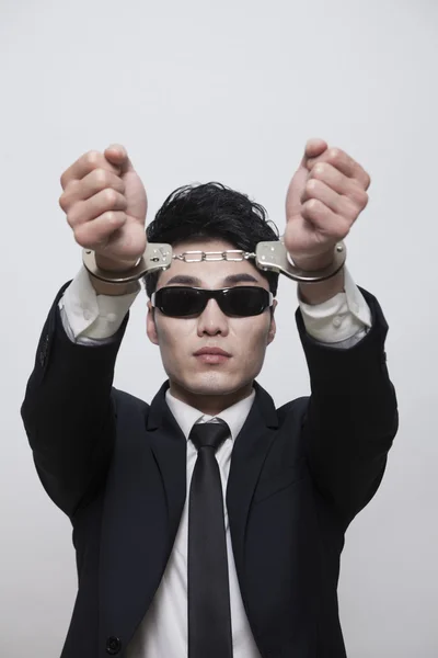 Businessman with sunglasses in handcuffs — Stock Photo, Image