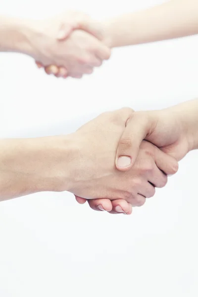 Four young people shaking hands — Stock Photo, Image