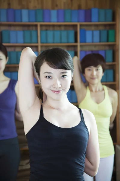 Mujeres estirándose y haciendo yoga — Foto de Stock