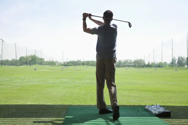 Mann schlägt Golfbälle auf dem Golfplatz — Stockfoto