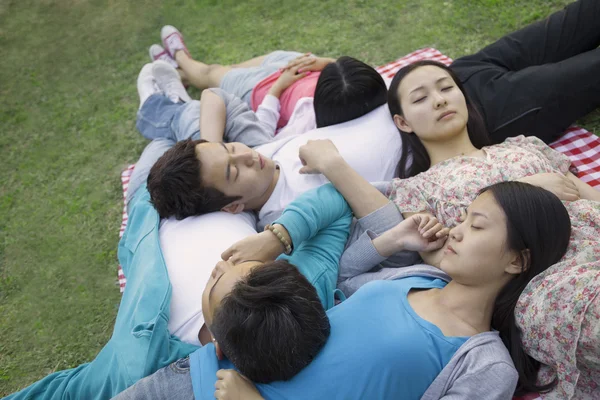 Amigos descansando uno sobre el otro durante un picnic —  Fotos de Stock