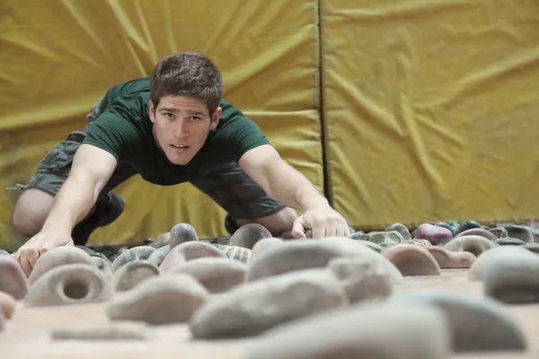 Man climbing up a climbing wall — Stock Photo, Image