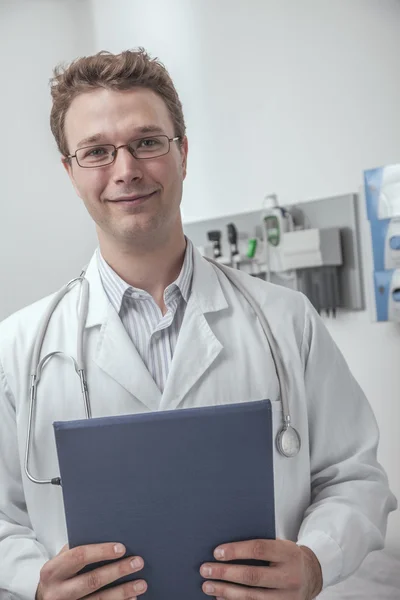 Médecin souriant tenant un presse-papiers — Photo