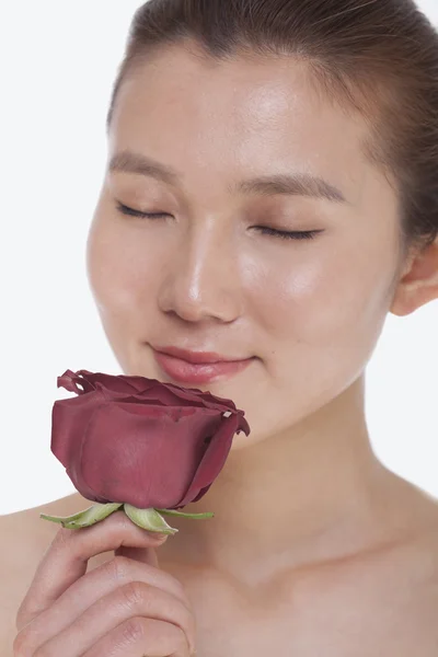 Mujer con los ojos cerrados oliendo una rosa roja —  Fotos de Stock