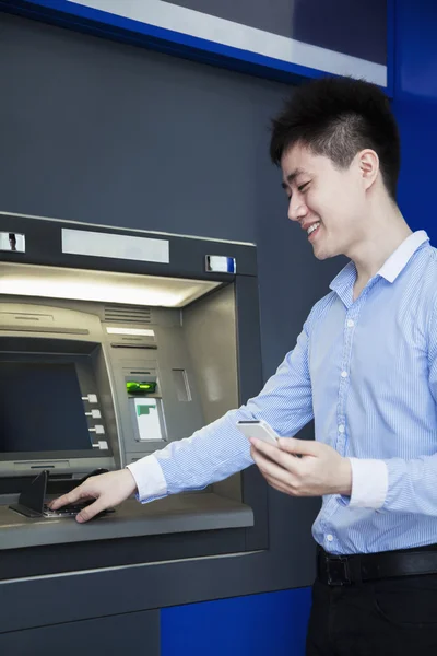 Бизнесмен снимает деньги в банкомате — стоковое фото