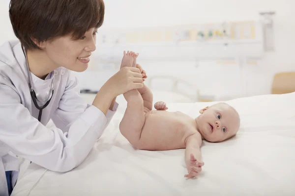 Médico examinando um bebê no consultório médico — Fotografia de Stock