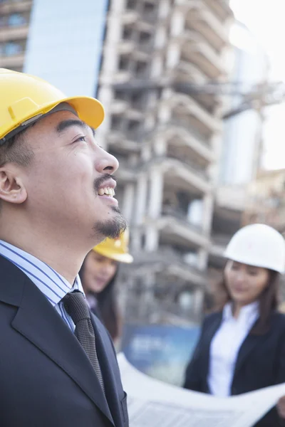 Architect with colleagues in background — Stock Photo, Image