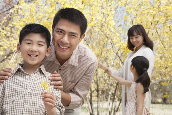 Genitori con due bambini che si godono il parco — Foto Stock