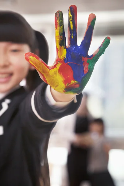 Smiling schoolgirl finger painting — Stock Photo, Image