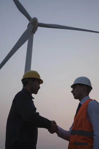 Ingenieros de pie junto a una turbina eólica —  Fotos de Stock