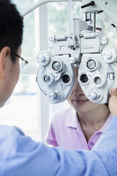 Optometrist fazendo um exame ocular em mulher jovem — Fotografia de Stock