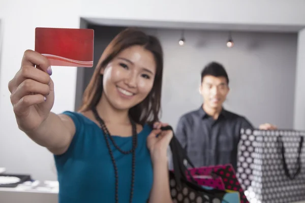 Žena držící kreditní kartou v obchodě s módní — Stock fotografie