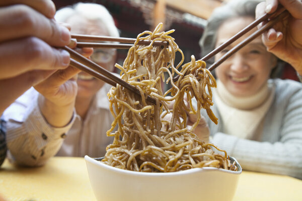 People sharing noodles