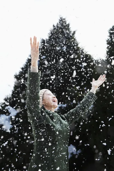 Vrouw met uitgestrekte armen gevoel van de sneeuw — Stockfoto
