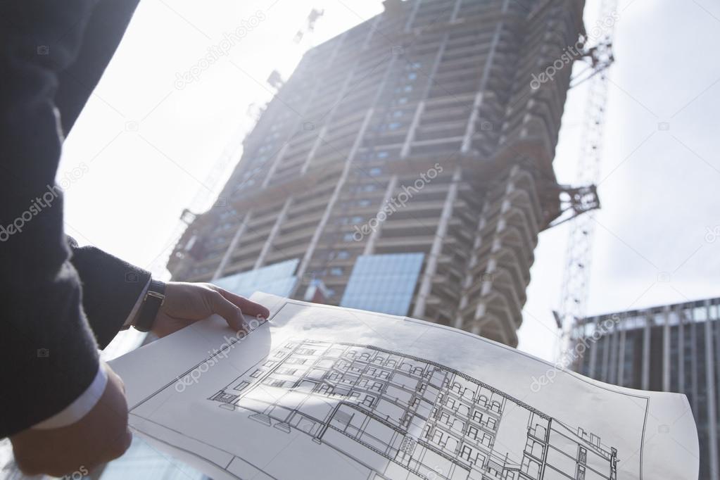 Architect holding blueprint of building
