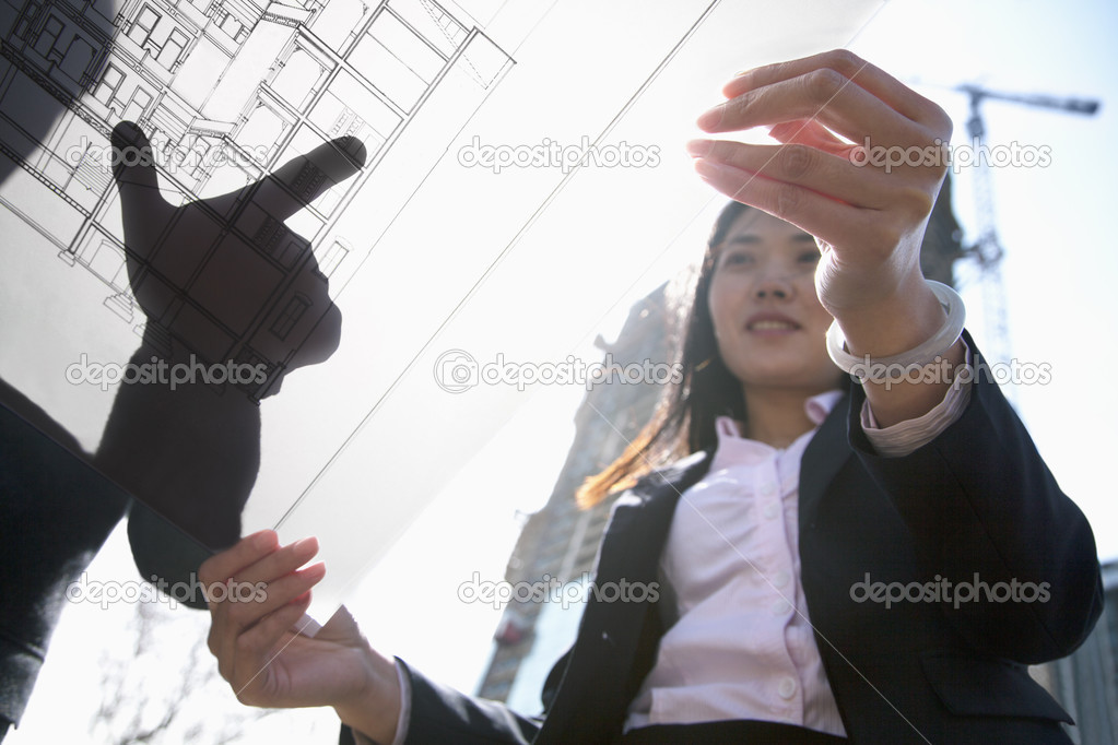 Architects looking at a blueprint at a construction site