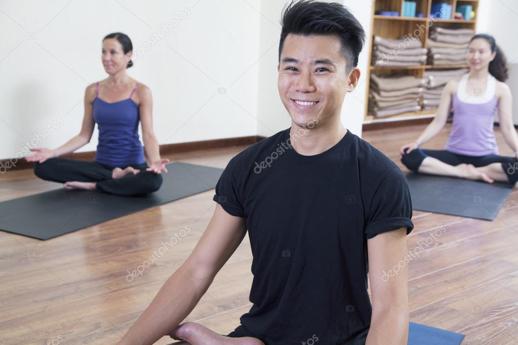 Man sitting cross-legged in a yoga class