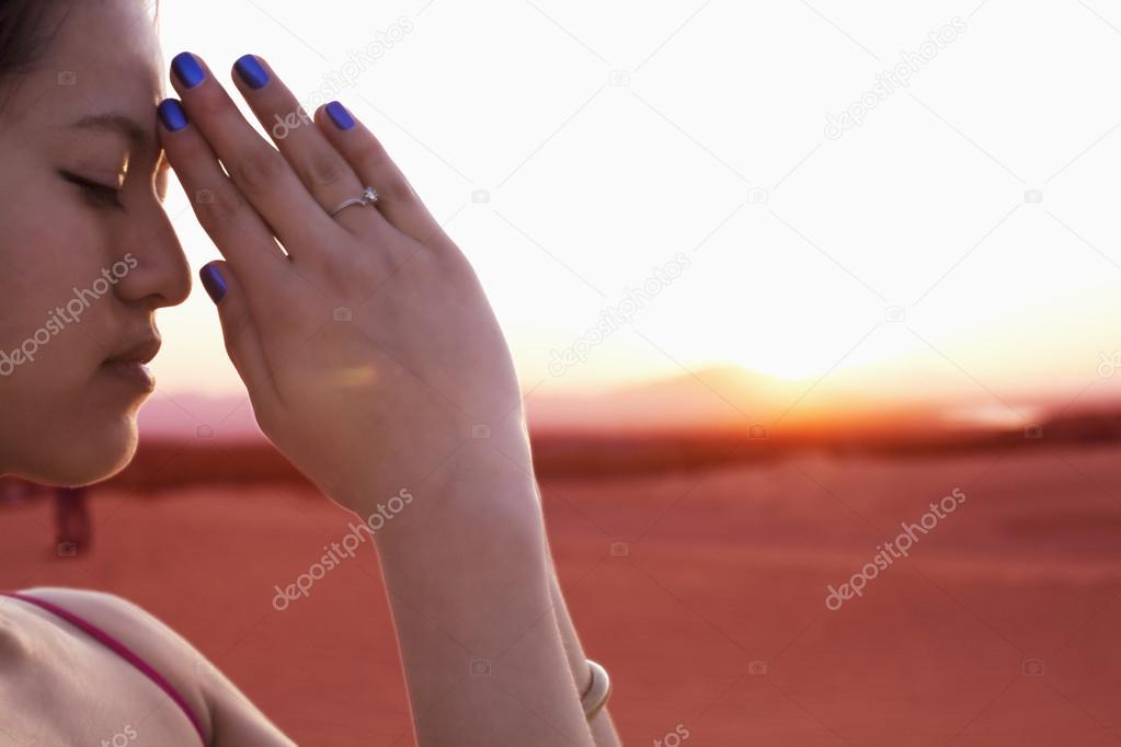 Woman with hands together in prayer pose